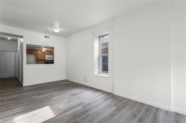4515 Margaretta Ave, Saint Louis, MO 63115 - unfurnished living room featuring wood finished floors and baseboards