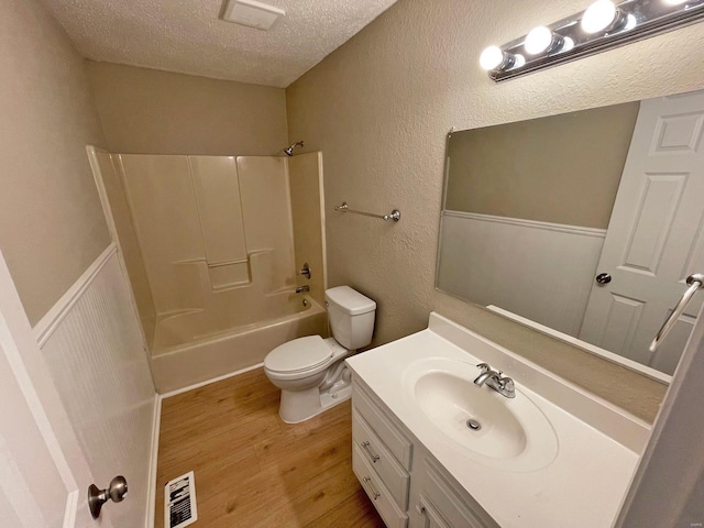 12 Lynnwood Ct, Belleville, IL 62226 - bathroom featuring a textured ceiling, wood finished floors, toilet, vanity, and bathtub / shower combination