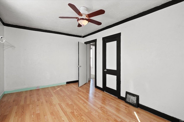 unfurnished room featuring crown molding, light wood-style floors, ceiling fan, baseboards, and a textured ceiling