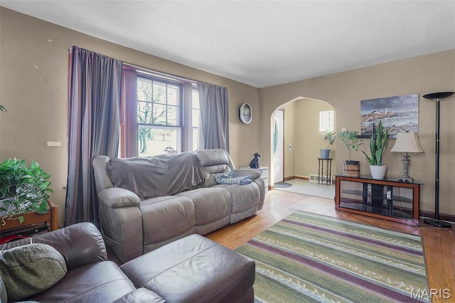 5800 Marquette Ave, Saint Louis, MO 63139 - living area featuring arched walkways, healthy amount of natural light, light wood finished floors, and baseboards