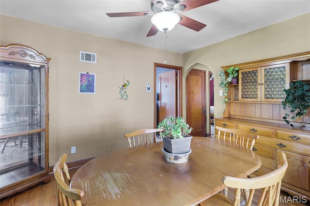 5800 Marquette Ave, Saint Louis, MO 63139 - dining space featuring arched walkways, a ceiling fan, and wood finished floors