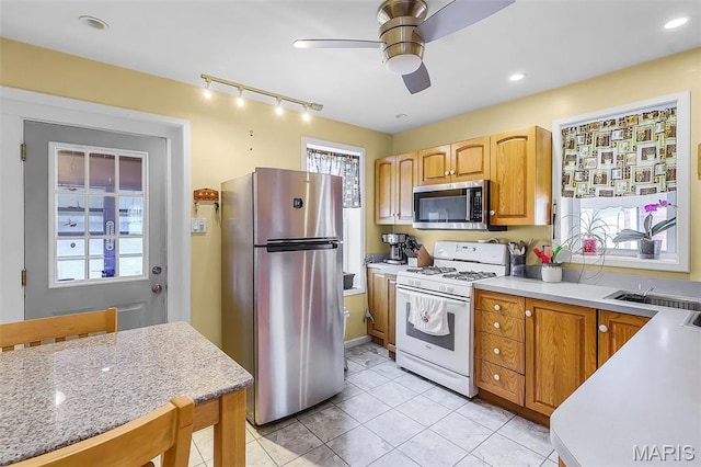 5800 Marquette Ave, Saint Louis, MO 63139 - kitchen with appliances with stainless steel finishes, ceiling fan, light tile patterned floors, track lighting, and light stone countertops