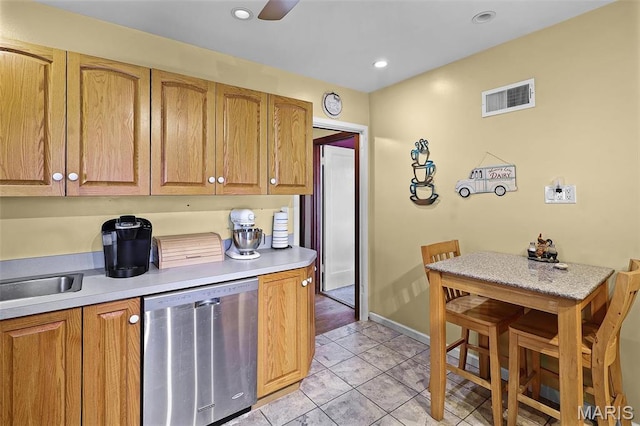 5800 Marquette Ave, Saint Louis, MO 63139 - kitchen with stainless steel dishwasher, light countertops, light tile patterned floors, a sink, and recessed lighting