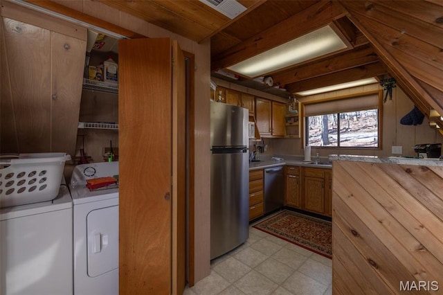1703 Wynnbrook Woods Dr, Innsbrook, MO 63390 - kitchen with stainless steel appliances, washing machine and clothes dryer, light floors, brown cabinetry, and light countertops