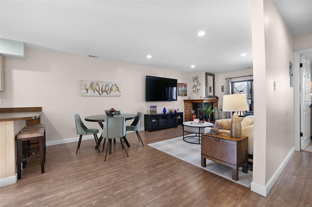 living room with wood finished floors, baseboards, and recessed lighting