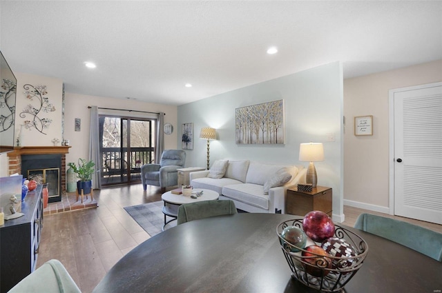 living room featuring light wood finished floors, recessed lighting, a fireplace, and baseboards