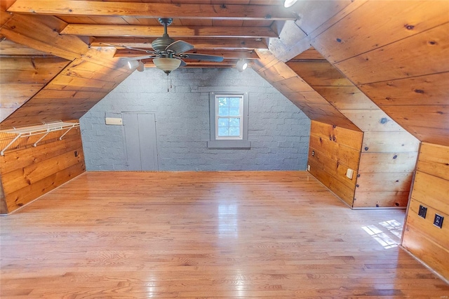 additional living space with hardwood / wood-style flooring, wood ceiling, wood walls, and ceiling fan