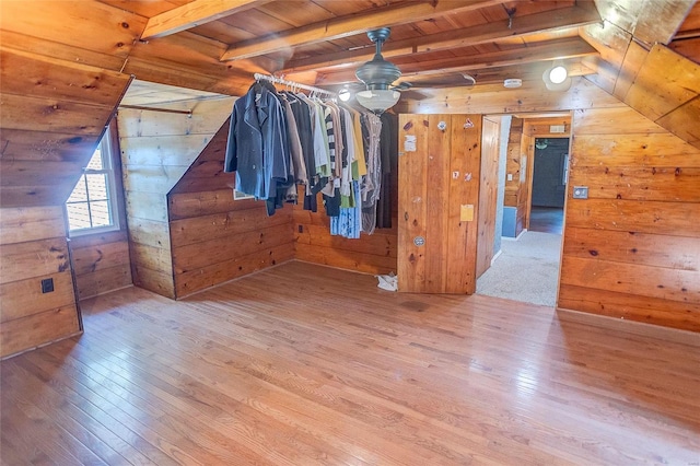 additional living space featuring wooden walls, hardwood / wood-style flooring, wood ceiling, and ceiling fan