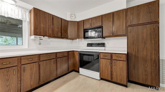 912 Salem Way, Ellisville, MO 63021 - kitchen with black microwave, white range with electric cooktop, light wood-style flooring, and light countertops