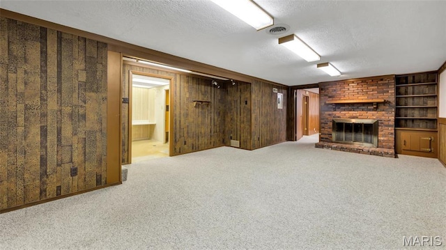 912 Salem Way, Ellisville, MO 63021 - finished basement featuring a textured ceiling, a brick fireplace, carpet flooring, and wood walls