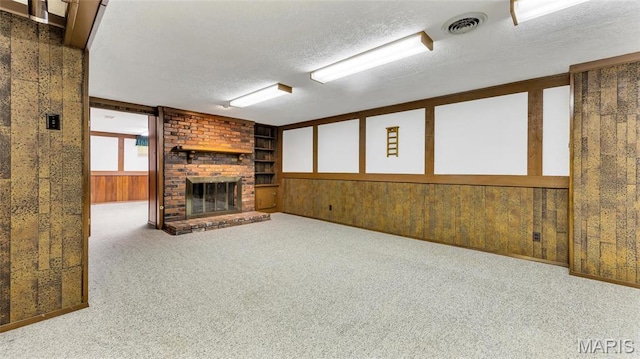 912 Salem Way, Ellisville, MO 63021 - unfurnished living room with a fireplace, a textured ceiling, carpet flooring, wood walls, and built in features