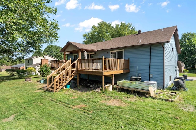 back of house featuring a yard, a wooden deck, a shingled roof, and central AC
