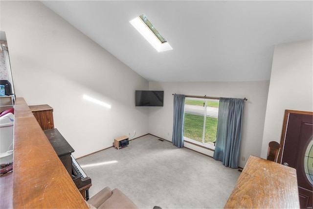 living room featuring vaulted ceiling, a skylight, and carpet floors