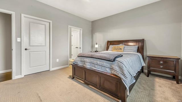 carpeted bedroom featuring baseboards and ensuite bath