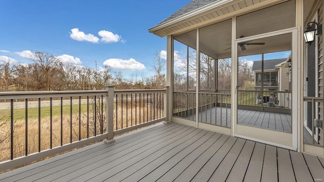 wooden deck with ceiling fan and a sunroom