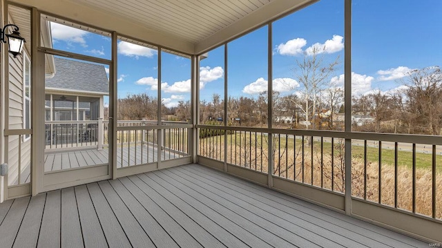 unfurnished sunroom with view of wooded area and plenty of natural light