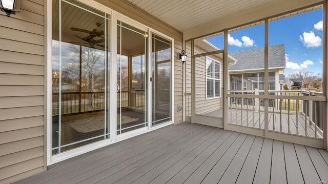 unfurnished sunroom featuring ceiling fan