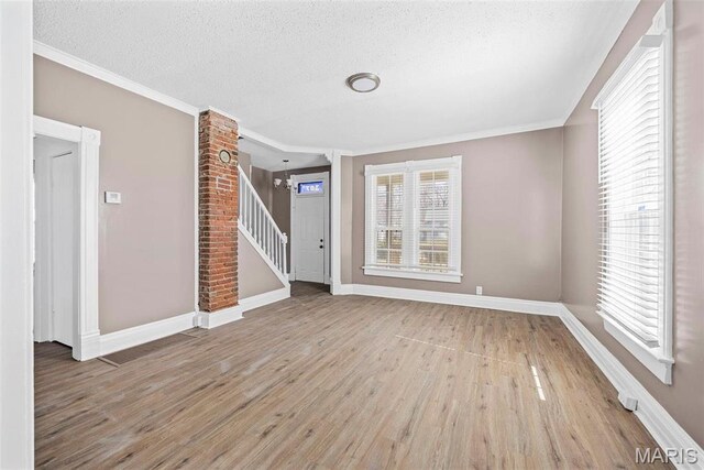 307 S State Highway 47, Warrenton, MO 63383 - unfurnished living room featuring wood finished floors, baseboards, stairs, crown molding, and a textured ceiling