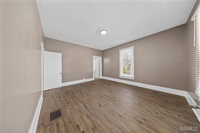 307 S State Highway 47, Warrenton, MO 63383 - empty room with wood finished floors, baseboards, and a textured ceiling