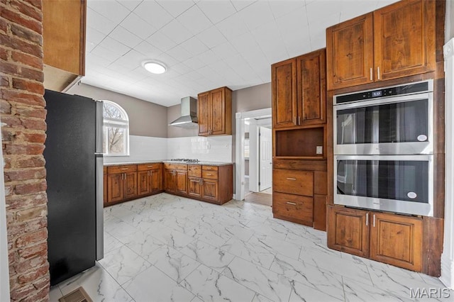 307 S State Highway 47, Warrenton, MO 63383 - kitchen featuring stainless steel appliances, wall chimney range hood, light marble finish flooring, brown cabinetry, and light countertops