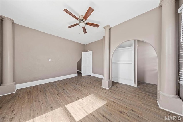 307 S State Highway 47, Warrenton, MO 63383 - unfurnished living room with a ceiling fan, wood finished floors, decorative columns, baseboards, and arched walkways