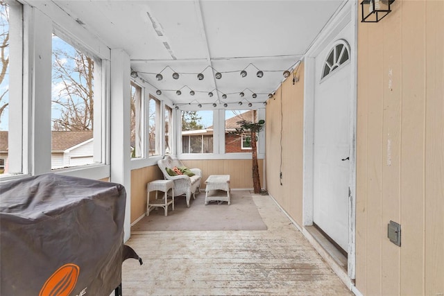 sunroom / solarium featuring wooden walls, wood-type flooring, and a wooden deck