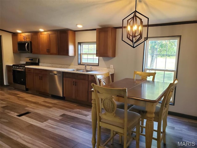 19983 Oak Dr, Carlyle, IL 62231 - kitchen with appliances with stainless steel finishes, a sink, light countertops, a chandelier, and dark wood finished floors