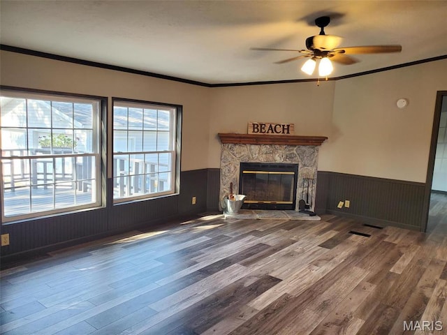 19983 Oak Dr, Carlyle, IL 62231 - unfurnished living room with a wainscoted wall, wood finished floors, ceiling fan, a fireplace, and crown molding