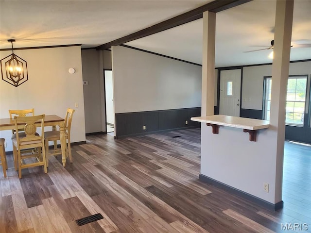 19983 Oak Dr, Carlyle, IL 62231 - kitchen featuring dark wood finished floors, a kitchen bar, light countertops, a ceiling fan, and ornamental molding
