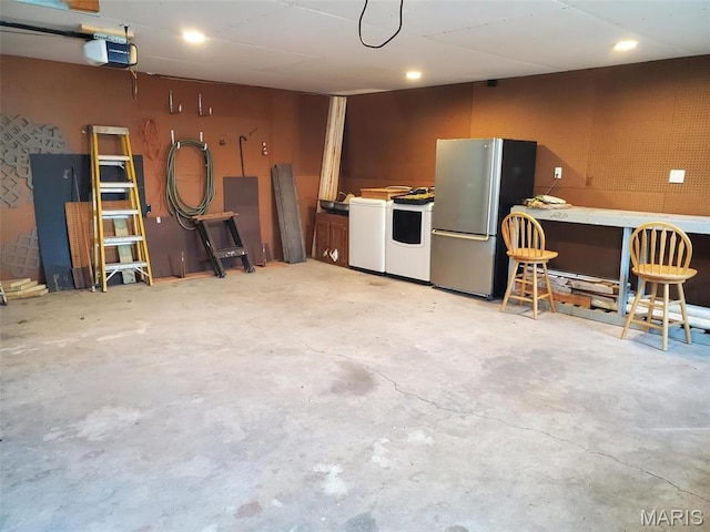 19983 Oak Dr, Carlyle, IL 62231 - garage featuring freestanding refrigerator, washer / clothes dryer, a garage door opener, and a workshop area