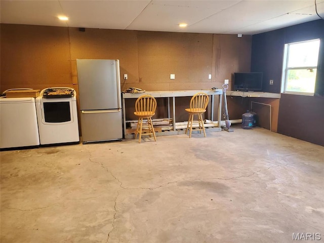 19983 Oak Dr, Carlyle, IL 62231 - kitchen featuring freestanding refrigerator, unfinished concrete floors, a kitchen breakfast bar, and washer and dryer