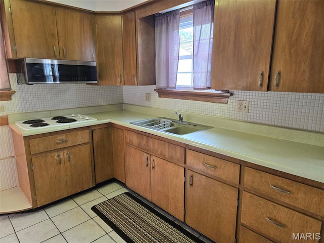 1450 Mulliken St, Carlyle, IL 62231 - kitchen featuring white electric stovetop, a sink, light countertops, stainless steel microwave, and decorative backsplash