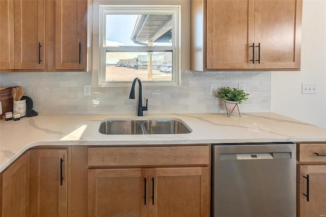 kitchen with dishwasher, a sink, backsplash, and light stone counters