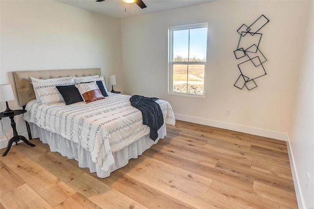 bedroom featuring light wood-style flooring, baseboards, and a ceiling fan