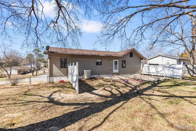 rear view of property with fence, a patio area, and central AC