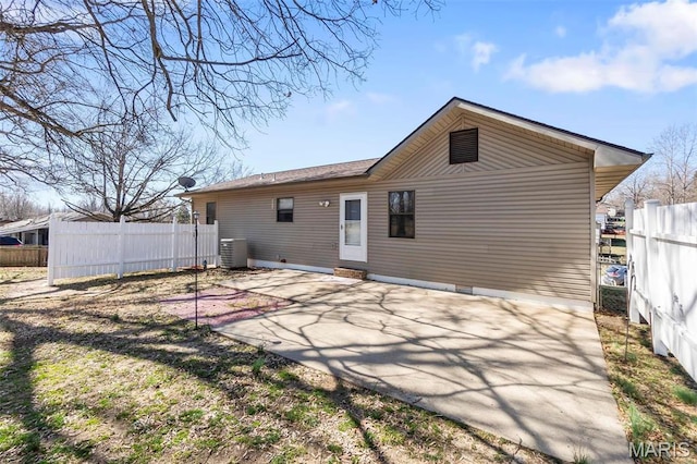rear view of house featuring fence, central air condition unit, and a patio