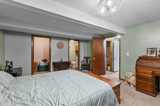 carpeted bedroom featuring a textured ceiling and ensuite bath