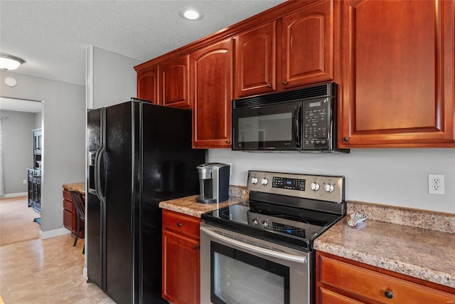 kitchen with black appliances, a textured ceiling, and baseboards
