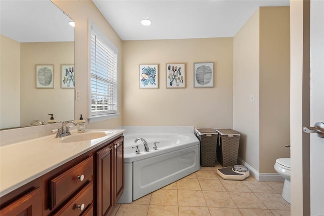 bathroom with a bath, toilet, vanity, tile patterned flooring, and baseboards