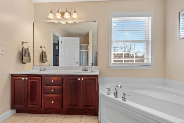 bathroom with a bath, healthy amount of natural light, double vanity, and tile patterned flooring