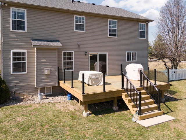 rear view of house featuring a deck and a shingled roof