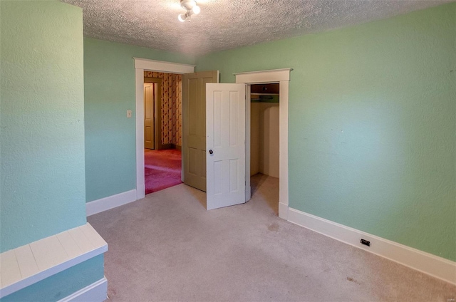 216 S Dickey St, Sparta, IL 62286 - unfurnished bedroom featuring a textured ceiling, light carpet, a closet, baseboards, and a textured wall