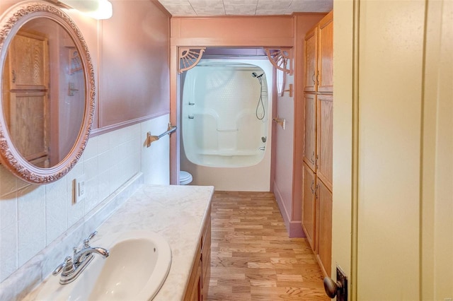 216 S Dickey St, Sparta, IL 62286 - bathroom featuring wood finished floors, a shower, vanity, and backsplash
