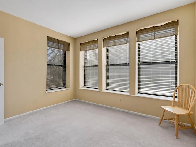 carpeted empty room with baseboards and plenty of natural light