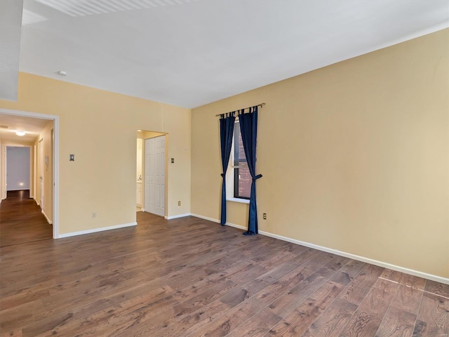empty room with dark wood-style floors and baseboards