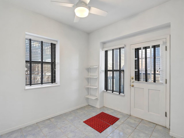doorway to outside with light tile patterned flooring, baseboards, and ceiling fan
