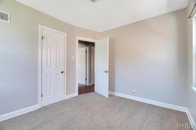 unfurnished bedroom featuring carpet floors and baseboards