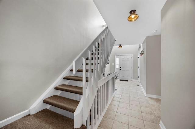 stairs with baseboards and tile patterned floors