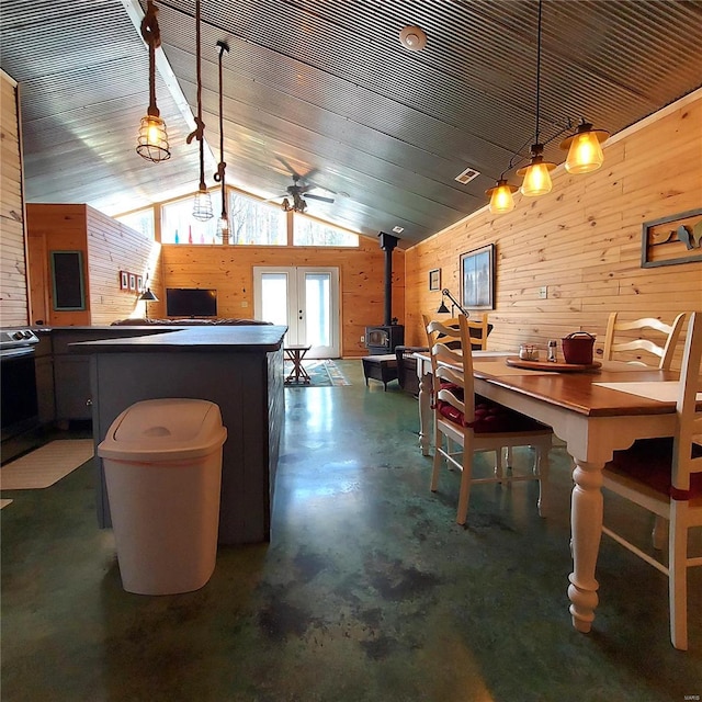 1432 Wayne 523, Wappapello, MO 63966 - dining space with a wood stove, wood walls, concrete flooring, lofted ceiling, and a ceiling fan
