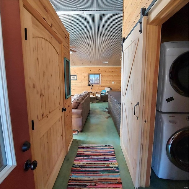 1432 Wayne 523, Wappapello, MO 63966 - laundry area with stacked washing machine and dryer, a barn door, and wooden walls